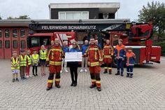 Carolin Dreismann, Präsidentin des Lions Club Lübecker Bucht, überreicht einen Scheck in Höhe von 4.000 Euro an Bo Anderson und David Siegmund für die Kinder- und Jugendfeuerwehr Scharbeutz.