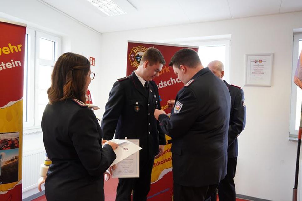 Tobias Weiffen (re.), Gruppenführer von Gruppe 1 der Freiwilligen Feuerwehr nimmt Finn Breede (2. v. lks.) in die Einsatzabteilung auf.