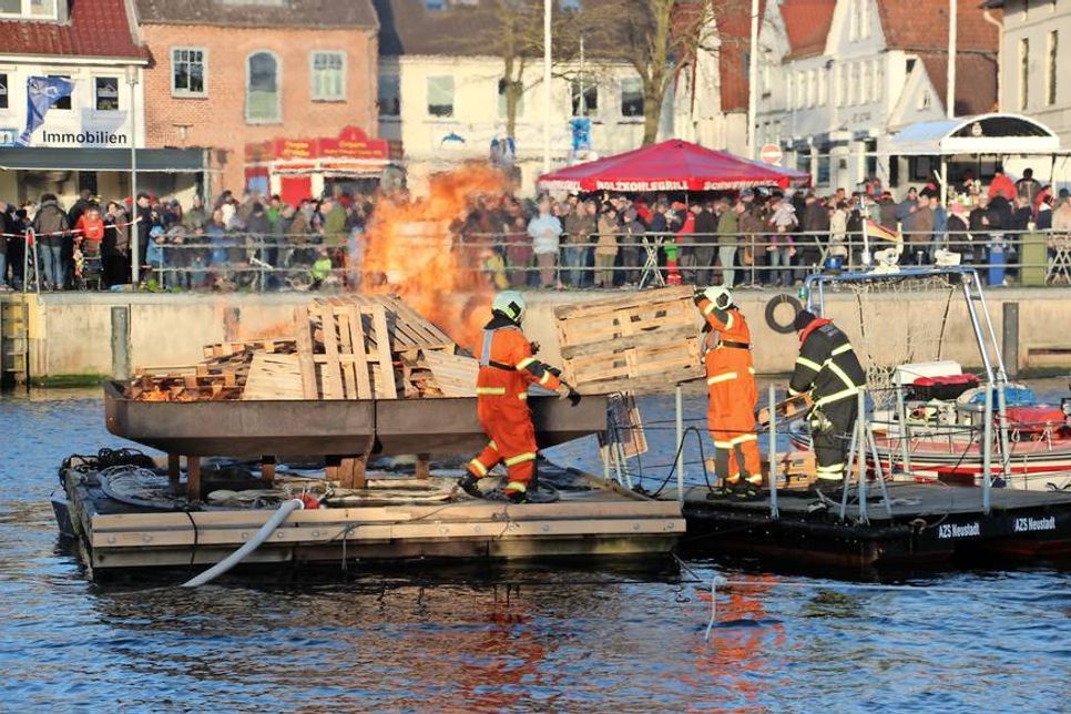 Die Kameraden der Freiwilligen Feuerwehr legen Holz nach.
