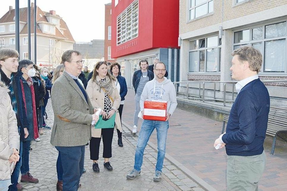 Mit betroffenen Eltern, Schülern und Lehrkräften übergibt Arnd Hemmer (l., Schriftstück in der Hand) die 2.500 Unterschriften an Bad Schwartaus Bürgermeister Dr. Uwe Brinkmann (r.).