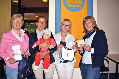 Barbara Bergmann (v.li.), Silke Hüttmann (mit Milena), Bianca Janßen und Gudrun Banaski vom Fachdienst Bildung, Sport und Familienangelegenheiten mit einigen Inhalten des Begrüßungspaketes für Neugeborene. (Foto: René Kleinschmidt)