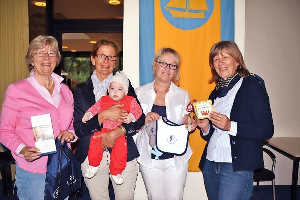 Barbara Bergmann (v.li.), Silke Hüttmann (mit Milena), Bianca Janßen und Gudrun Banaski vom Fachdienst Bildung, Sport und Familienangelegenheiten mit einigen Inhalten des Begrüßungspaketes für Neugeborene. (Foto: René Kleinschmidt)