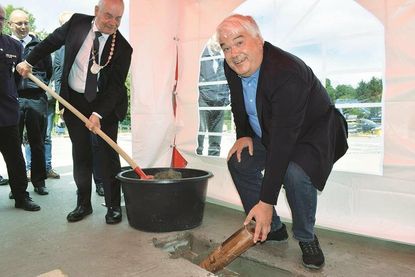 Zusammen mit Schönkirchens Bürgermeister Gerd Radisch griff Bürgervorsteher Thorsten Stich (v. l.) zu Schaufel und Maurerkelle und versenkte die Zeitkapsel im Fundament.