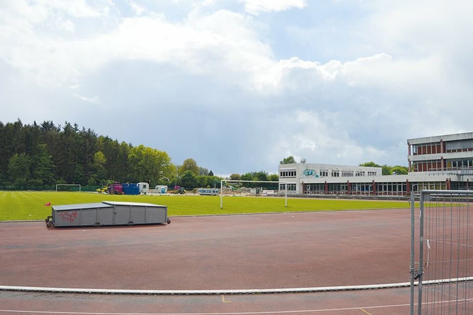 Auf rund einem Viertel der Rasenfläche wurde die Baustelle für den Neubau des Gymnasiums eingerichtet. Weitere Fahrzeuge und Gerätschaften folgen und werden vermutlich die Hälfte des Sportplatzes belegen, wenn es richtig losgeht.