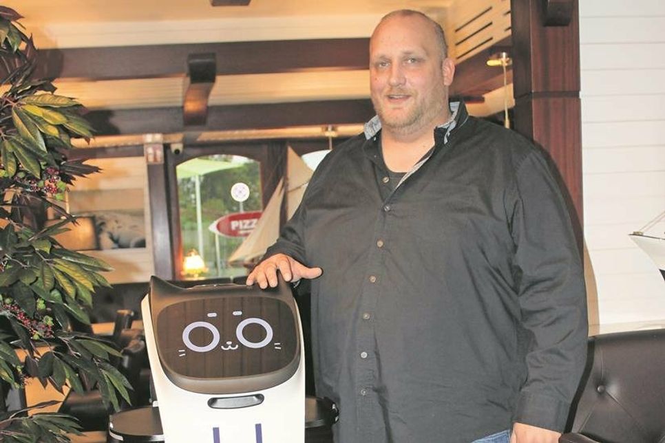 Hafenrestaurant-Chef Tim Bornewasser mit dem Service-Roboter, der seit dem gestrigen Freitag im Einsatz ist.