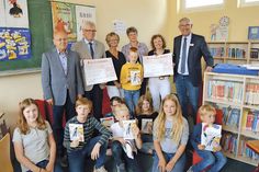 Hans Peter Birkner (v.l.) und Reimer Rohde von der Bürger-Stiftung Ostholstein sowie die Schulleiterinnen Petra Westphal, Karin Stender und Wiebke Raub-Mennerich nehmen mit einigen Schülern der Achim-Bröger-Schule die Spendenschecks von Warenhausleiter Peter Bünnng entgegen. (Foto: Stefan Setje-Eilers)