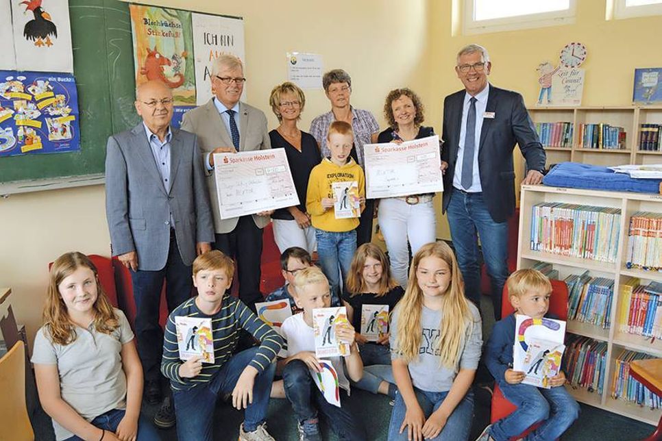 Hans Peter Birkner (v.l.) und Reimer Rohde von der Bürger-Stiftung Ostholstein sowie die Schulleiterinnen Petra Westphal, Karin Stender und Wiebke Raub-Mennerich nehmen mit einigen Schülern der Achim-Bröger-Schule die Spendenschecks von Warenhausleiter Peter Bünnng entgegen. (Foto: Stefan Setje-Eilers)