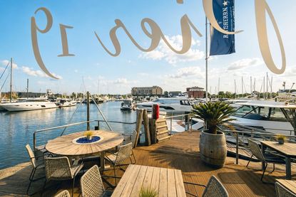 Auf der Sonnenterrasse genießen Gäste feinste Kulinarik mit Blick auf die Marina.