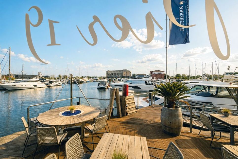 Auf der Sonnenterrasse genießen Gäste feinste Kulinarik mit Blick auf die Marina.
