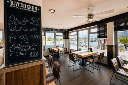 Die Terrassentische entstanden aus Holz alter Stege der Marina und erzählen ein Stück Hafengeschichte.