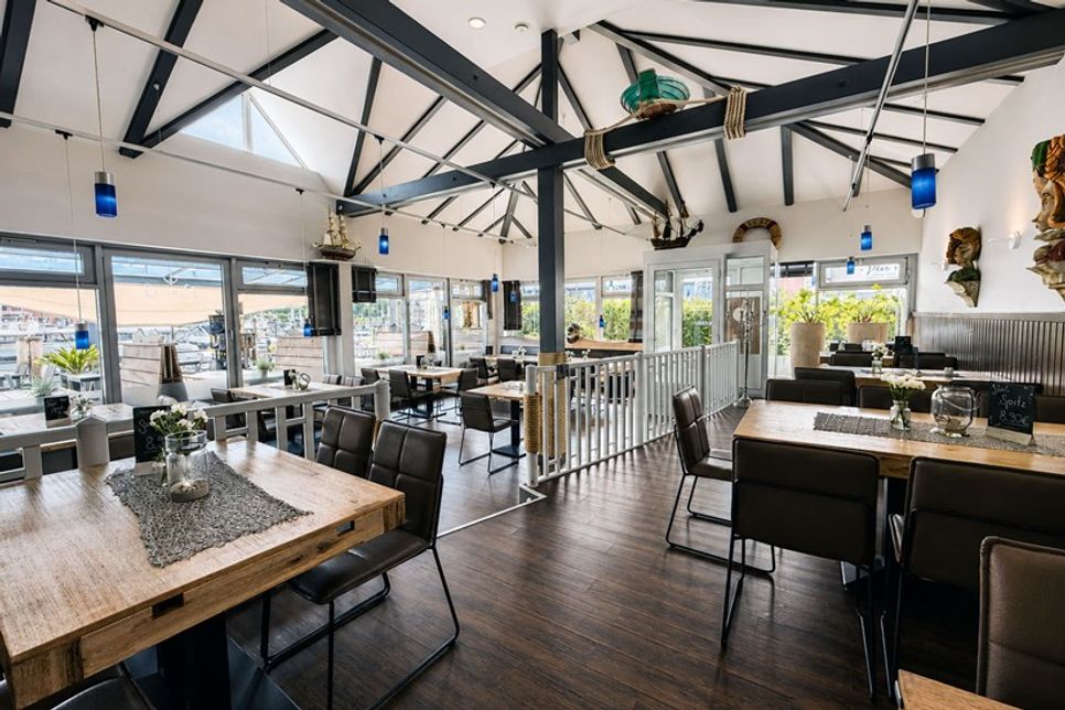 Die Terrassentische entstanden aus Holz alter Stege der Marina und erzählen ein Stück Hafengeschichte.