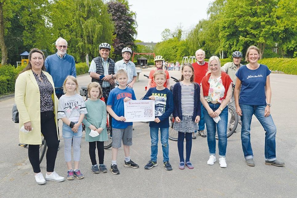 Am gestrigen Dienstagmorgen übergaben Volker Olbers (4.v.r.), Vorsitzender der Bürgerstiftung Stockelsdorf, und Hugo Grosse Banholt (2.v.l.), Leiter der Fahrradgruppe, mit einer „Abordnung“ die erradelte Summe an Schulleiterin Claudia Böbs (r.) und einige ihrer Kolleginnen und Schüler.
