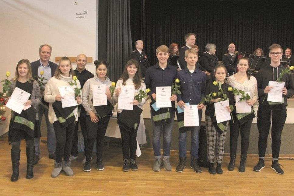 Gemeindewehrführer Björn Sachau (re) vereidigte feierlich die neuen Feuerwehrfrauen und -männer.