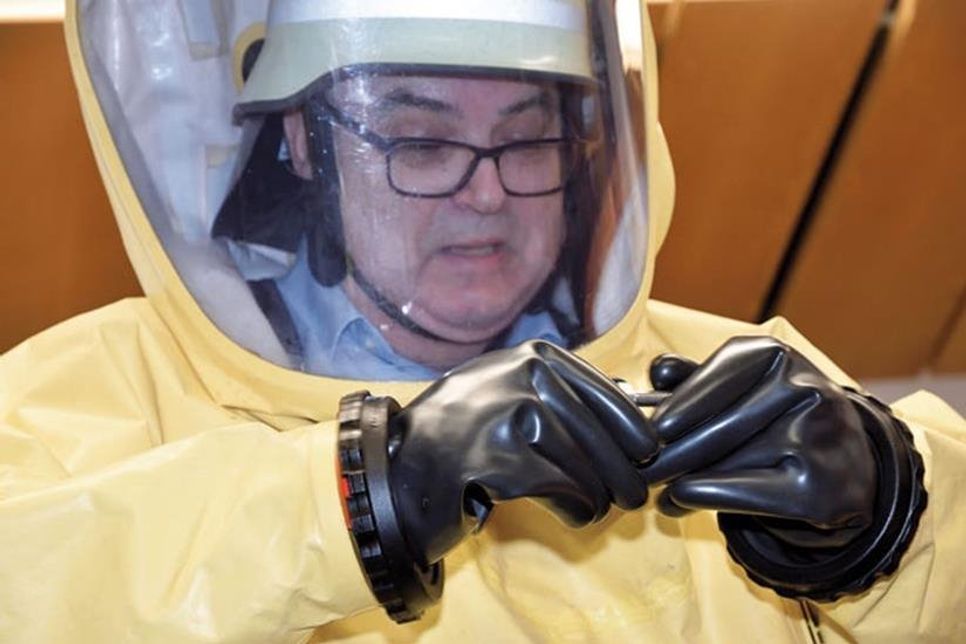 Gut verpackt im Chemieschutzanzug bewies der künftige Ruheständler noch Fingerfertigkeit beim Schrauben drehen.