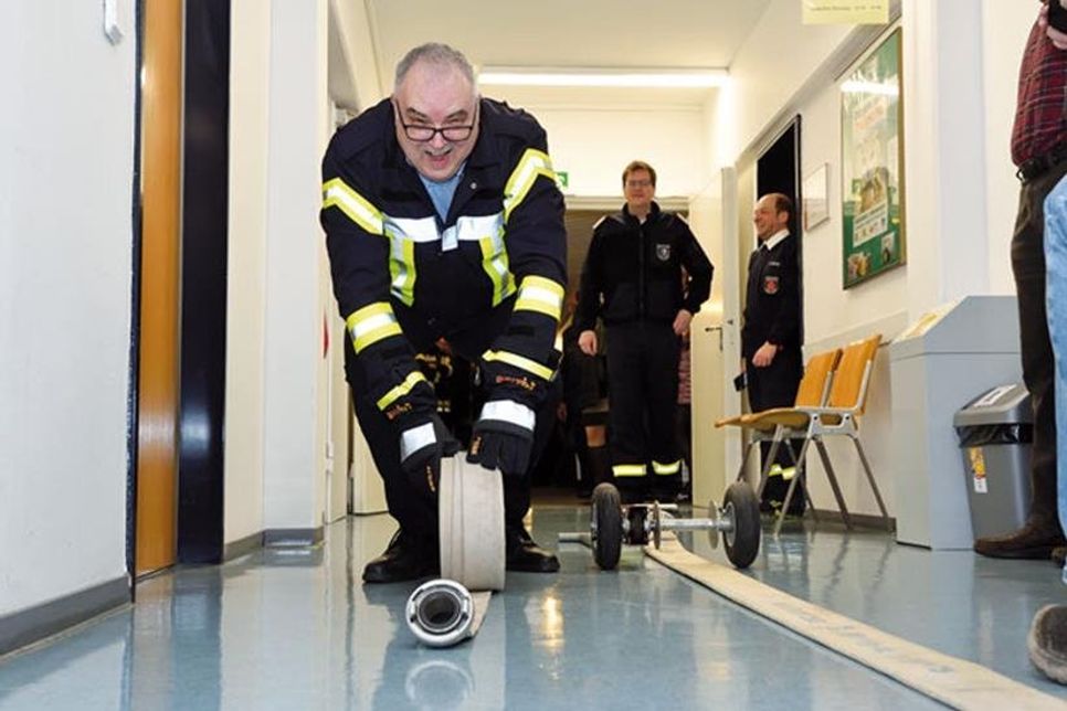 Präzisionsarbeit: Harald Koopmann beim Aufrollen der Feuerwehrschläuche in den Fluren des Kreisehauses.