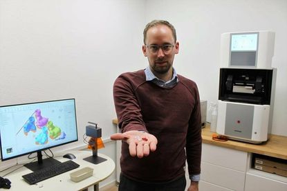 Inhaber und Hörakustikmeister Christoph Schulte präsentiert frisch gedruckte Hightechprodukte für die Ohren. Rechts das neue 3D-Druck-System des Fertigungs-Spezialisten Rapidshape aus Baden-Württemberg, links die Modelle am PC.