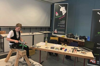 Laptop und Schieferhammer, zwei wichtige Begleiter in der Dachdeckerausbildung. Foto: ZVDH/akz-o