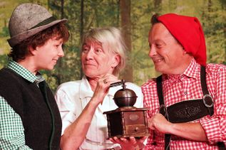 Die Großmutter (Sylvia Glismann) freut sich über die Kaffeemühle, die Seppel (Marcia Talleur, l.) und Kasperl (Marc Wiens) ihr geschenkt haben.