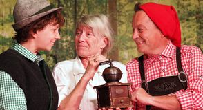 Die Großmutter (Sylvia Glismann) freut sich über die Kaffeemühle, die Seppel (Marcia Talleur, l.) und Kasperl (Marc Wiens) ihr geschenkt haben.