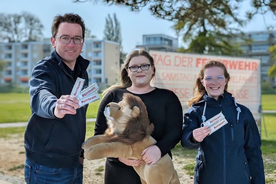 Ortswehrführer Jacob Revenstorf mit Marie Munzel und Johanna Kruse von der Kinderfeuerwehr (v. lks.) werden Schlüsselanhänger verkaufen.