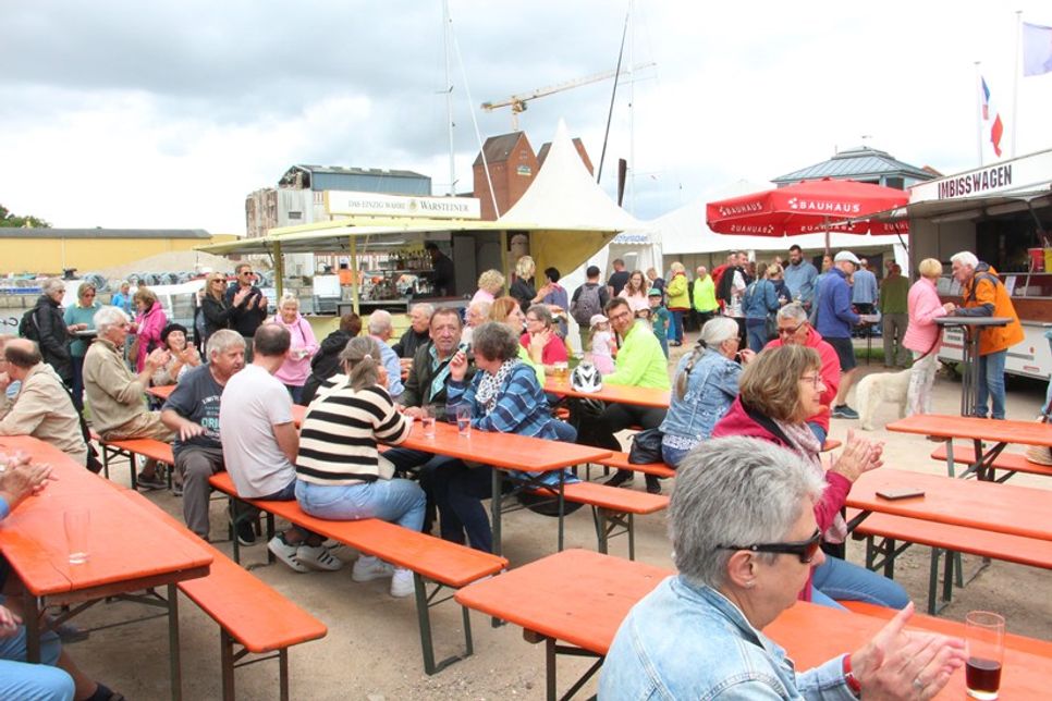 Auf dem Netztrockenplatz genießen die Gäste regionale Spezialitäten, Livemusik und maritime Atmosphäre.