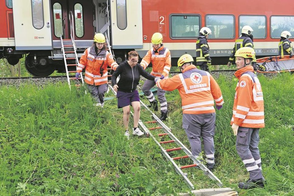 Von der Feuerwehr aus dem Zug geholt, wurden die Personen vom DRK in Empfang genommen.