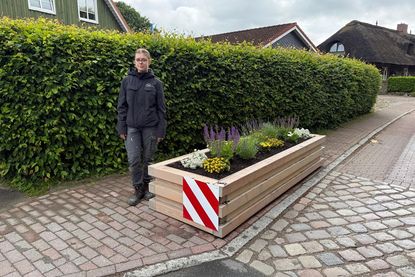 Auszubildende Cecile Nebel präsentiert den neu gefertigten Blumenkasten, den sie gemeinsam mit ihrem Ausbildungskollegen Hauke Groth eigenständig geplant und gebaut hat.