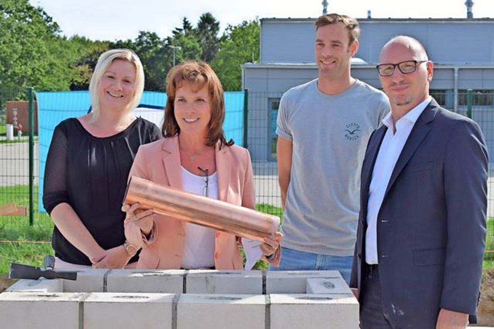 Versenkten die Kupferkapsel im Grundstein: Bianca Lüßenhop (v.l.), Vorsitzende des Gesundheitsausschusses, Landrätin Stephanie Ladwig, Dennis Mihlan, Vorsitzender des Bau- und Umweltausschusses, und Jörg Früchtenicht vom Bremer Architekturbüro GSP