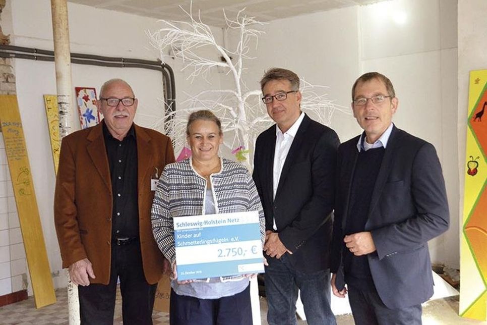 Holger Wessel (l.) und Susanne Lemke nehmen den symbolischen Spendenscheck von Thorsten Weber, Betriebsrat von Schleswig-Holstein Netz am Standort Ahrensburg, und Dr. Jörn Klimant, Personalvorstand der HanseWerk-Gruppe, entgegen.