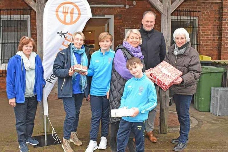 Steffi Dommasch (Mi.), Organisatorin der Weihnachtsgeschenke-Aktion des JFV Preetz, übergab mit ihren Kindern, Noah und Nick, an die Preetzer Tafel, hier Cornelia König (v.l.), Renate Beck, Björn Demmin und Dorit Kuhnt, die ersten gespendeten Päckchen für die Kinder aus den 280 Familien, die von der Tafel versorgt werden