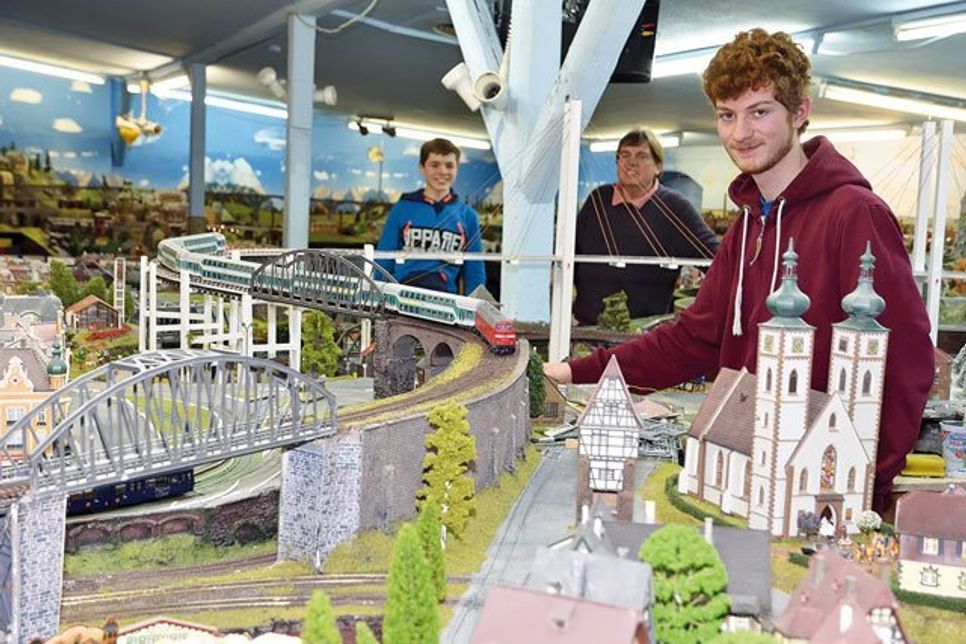 Hier läuft’s rund: (V. r.) Lukas (16), Projektleiter Robert Klein und Harry (14) lassen die Modelleisenbahn anfahren.