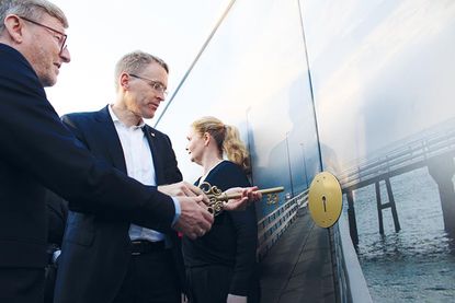 Ministerpräsident Daniel Günther beim Öffnen des Tores zur neuen Maritim-Seebrücke mit dem symbolischen Schlüssel.