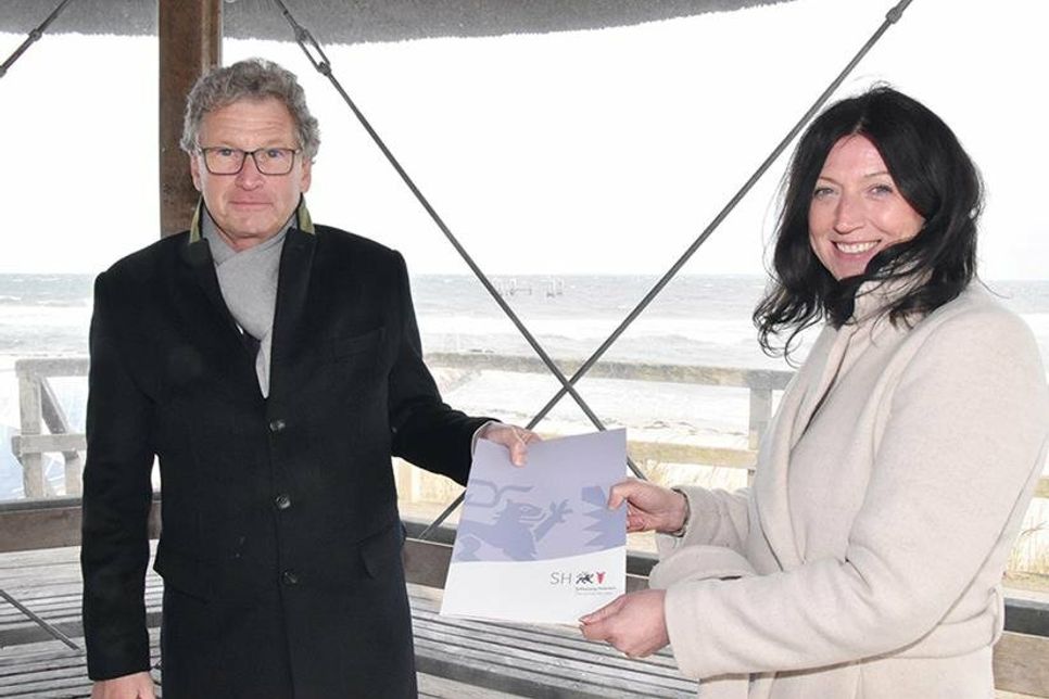 Wirtschafts- und Tourismusminister Dr. Bernd Buchholz bei der Übergabe des Förderbescheids an Bürgermeisterin Bettina Schäfer auf dem Seebrückenvorplatz in Haffkrug.