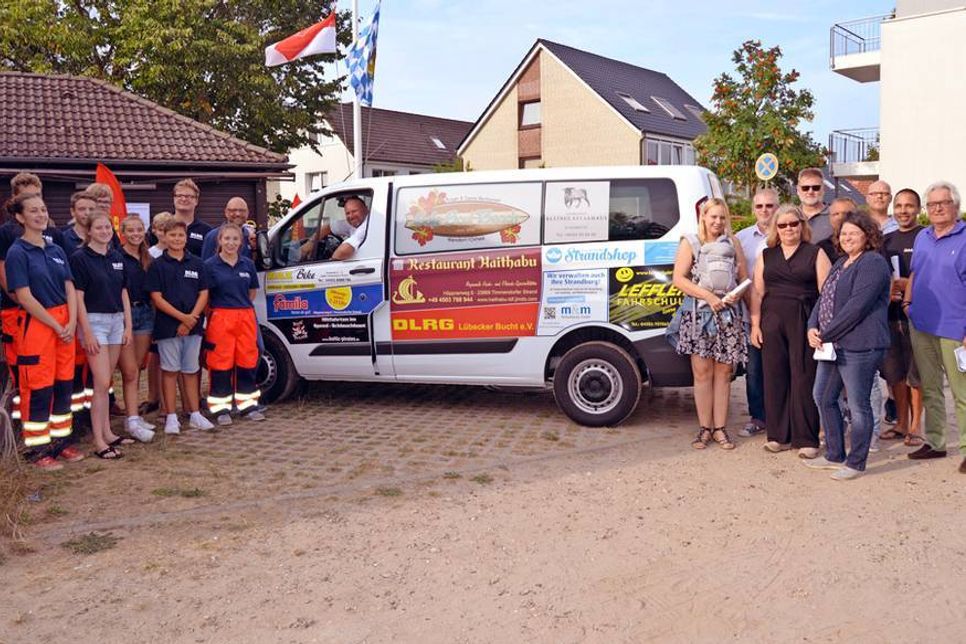 Gemeinsam mit einigen Werbepartnern (r.) nahmen die Mitglieder der DLRG Lübecker Bucht das neue Fahrzeug offiziell in Betrieb.