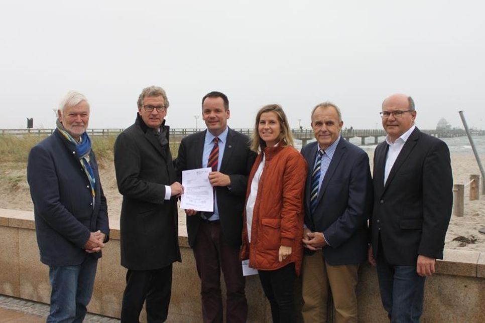 Wirtschaftsminister Dr. Bernd Buchholz (2. v. lks.) übergab den Förderbescheid an Bürgermeister Mark Burmeister (Mi.).