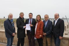 Wirtschaftsminister Dr. Bernd Buchholz (2. v. lks.) übergab den Förderbescheid an Bürgermeister Mark Burmeister (Mi.).