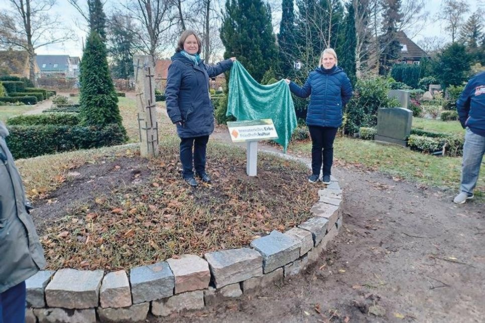 Nach der Begrüßung der Anwesenden und ihre einleitenden Worte enthüllten Pastorin Dr. Anne Smets (links) und Sandra Dettmann aus dem Kirchengemeinderat Ratekau das neue Schild.