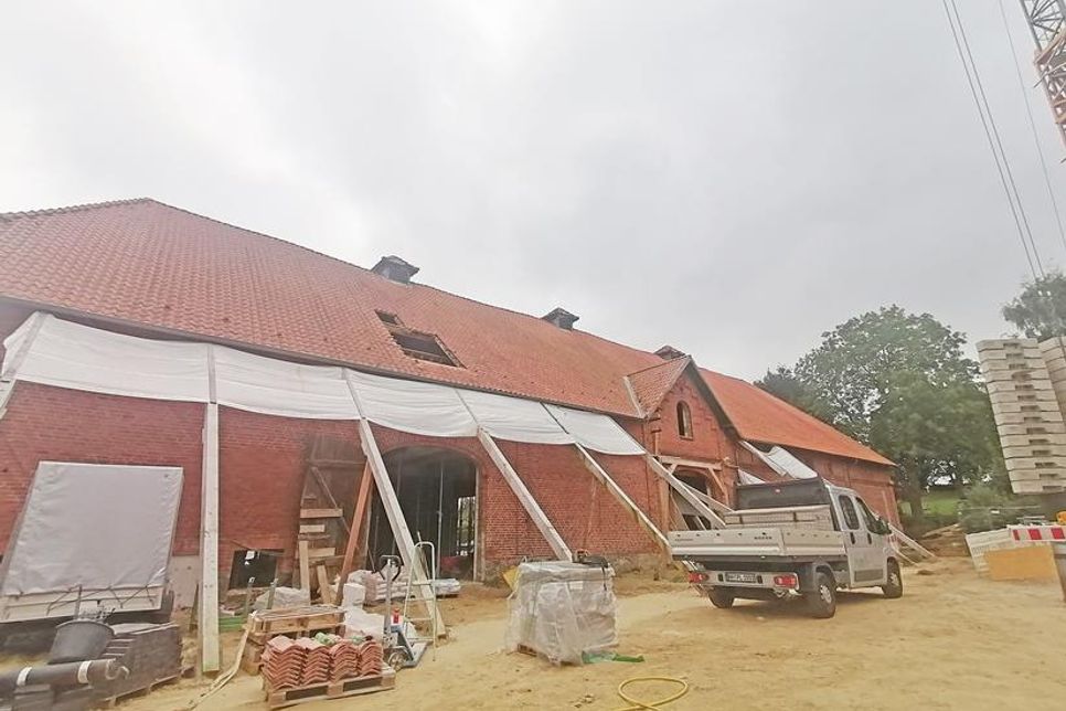 Die Hülle der Scheune auf dem Feddersen-Hof wird noch von Trägern gehalten, im Inneren ist der Rohbau der neuen Wohnungen und Gewerbeflächen fast vollendet.