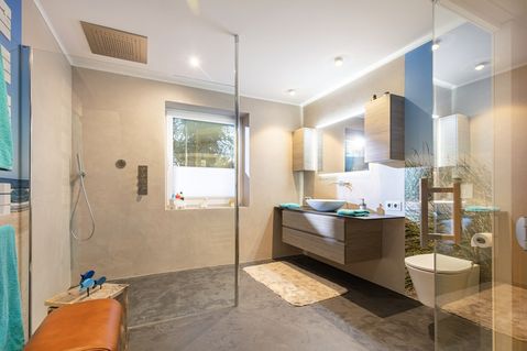 Ein großzügiges, fugenlos gestaltetes Bad zeigt, wie modernes Design und handwerkliche Präzision zu einem harmonischen Raumkonzept zusammenfinden.