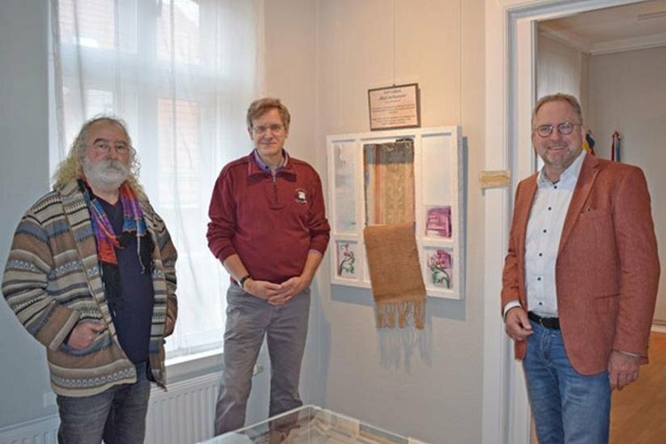 Fördervereinsvorsitzender Ralf Reikat (v.r.) und Heimatvereinsvorsitzender Axel Langfeldt freuen sich, dass das Bild von Atif Gülücü (li.) nun dauerhaft seinen Platz im Heimatmuseum hat.