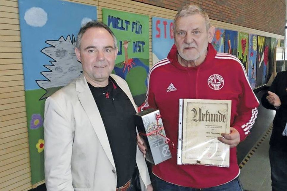 NTSV-Vorsitzender Andreas Block ehrt Willi Flemming für 60-jährige Mitgliedschaft mit Ehrennadel in Gold, Urkunde und Präsent. (Foto: Danzeglocke)