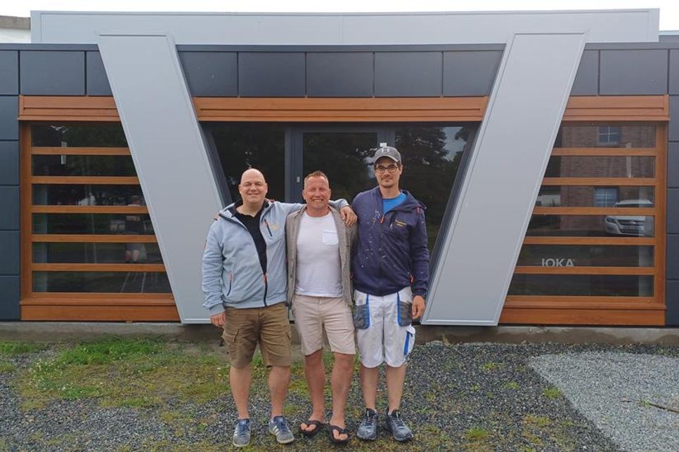 Geschäftsführer Christian Weidemann und Inhaber John Nestler mit Malermeister Benedict Fricke (v. lks.) vor dem nagelneuen Kunden-Container.