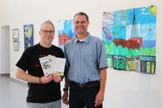 Diplom-Kunstpädagoge Reimer Faust vom Hans-Rahlfs-Haus (lks.) und Dr. Frank Wilschewski vom zeiTTor-Museum vor den künstlerischen Arbeiten der Neustädter Schüler.