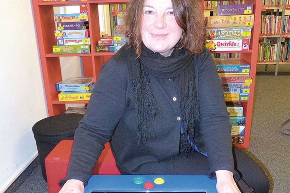Beate Sieweke, die Leiterin der Kreisbibliothek, mit KuTi, der neuen Spielekonsole der besonderen Art – der lustige Würfel bietet 18 Spiele und Quizze und kann von zwei bis zu sechs SpielerInnen genutzt werden. Der Spaß ist vorprogrammiert.