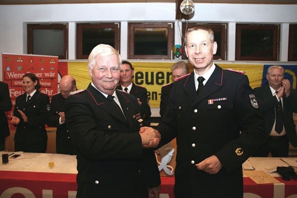Ortswehrführer Jörg Taube gratuliert Hugo Schneekloth (l.) für 60 Jahre Mitgliedschaft.