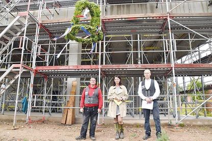 Betonbauer Thomas Klockmann (von links), Bürgermeisterin Bettina Schäfer und Polier René Zander nach dem Richtspruch unter dem Richtkranz, der jetzt über den Rohbau weht.