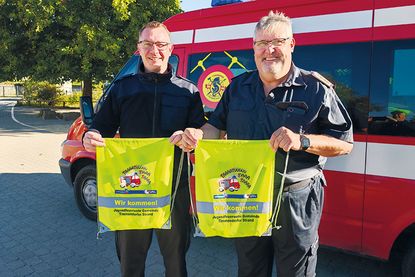 Gemeindejugendfeuerwehrwart Mirco Babin und Gemeindewehrführer Thomas Scharbau mit den Sportbeuteln, die sie kostenlos an die Erstklässler verteilt haben.