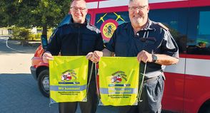 Gemeindejugendfeuerwehrwart Mirco Babin und Gemeindewehrführer Thomas Scharbau mit den Sportbeuteln, die sie kostenlos an die Erstklässler verteilt haben.