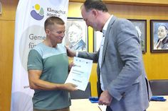 Landrat Björn Demmin (rechts) gratuliert Helge Ebert, der als Einzelradfahrer die meisten Kilometer zurücklegte.