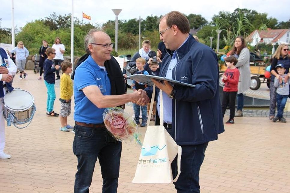 Robert Kleinwort ist seit 30 Jahrem Organisator des Kindervogelschießens in Pelzerhaken. Dafür dankte Bürgermeister Mirko Spieckermann unter anderem mit einem „Männerblumenstrauß“.